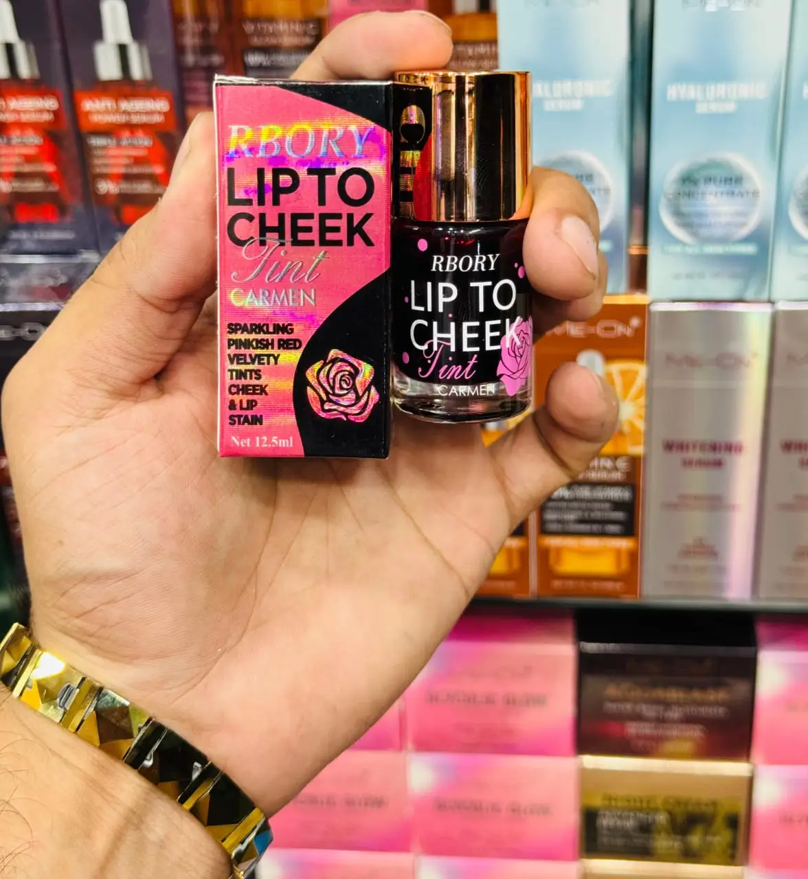 RBORY Lip to Cheek Tint in Carmen shade, sparkling pinkish-red velvety tint for lips and cheeks, 12.5ml bottle with packaging displayed.