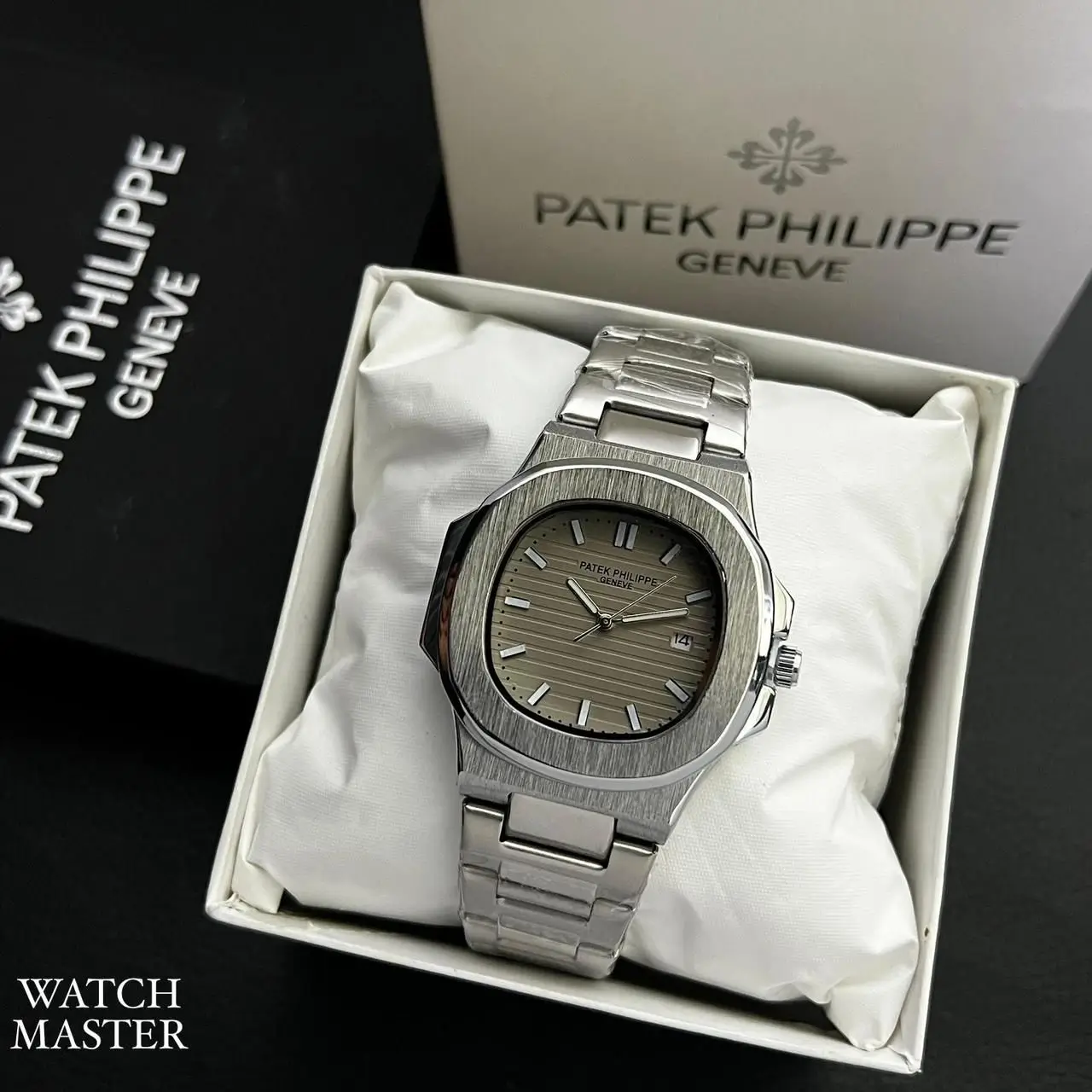Patek Philippe luxury wristwatch with a silver stainless steel strap and grey textured dial displayed in an elegant white box.