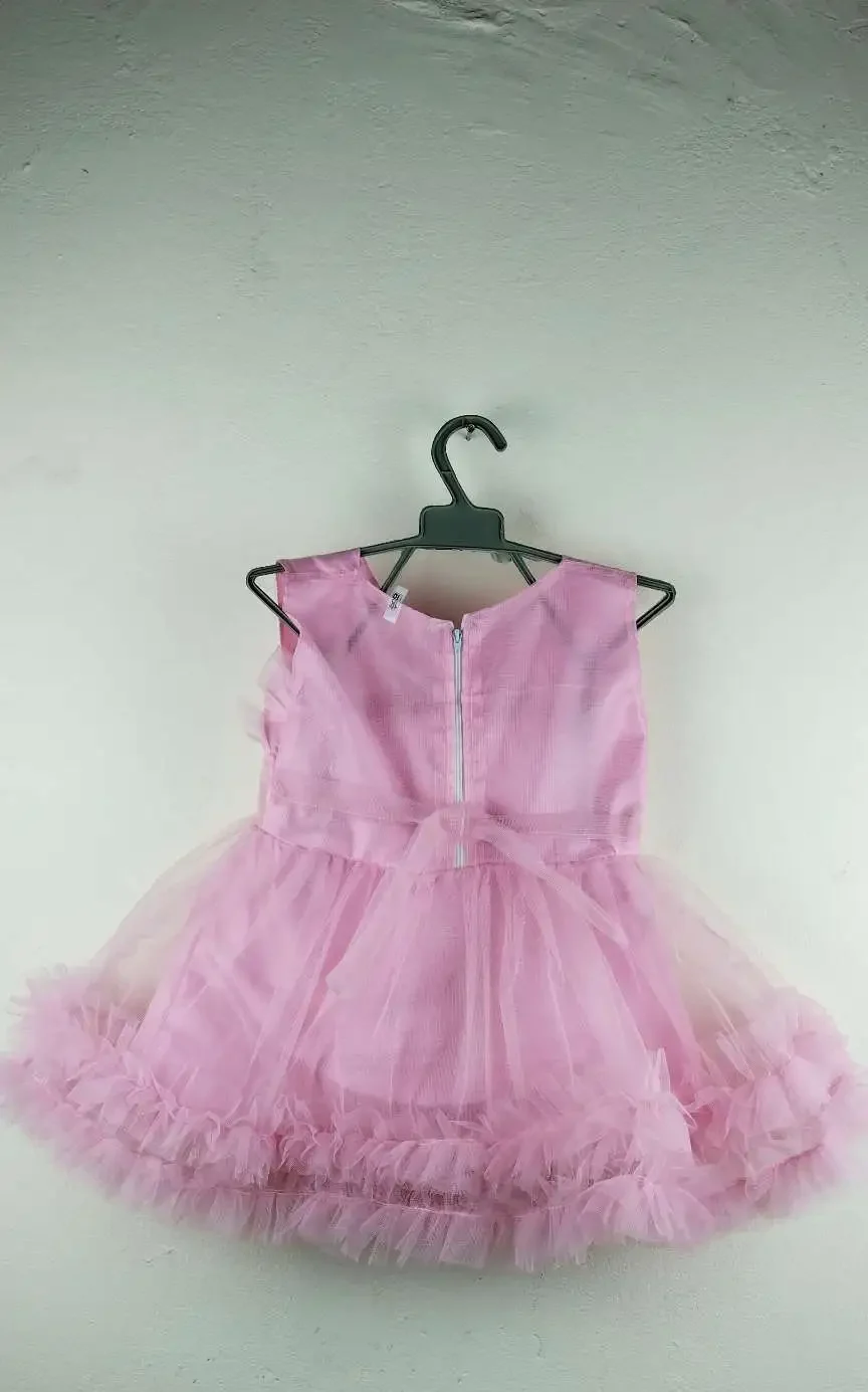 Light pink girls party dress with floral top design, flower waist detail, and fluffy layered skirt for special occasions