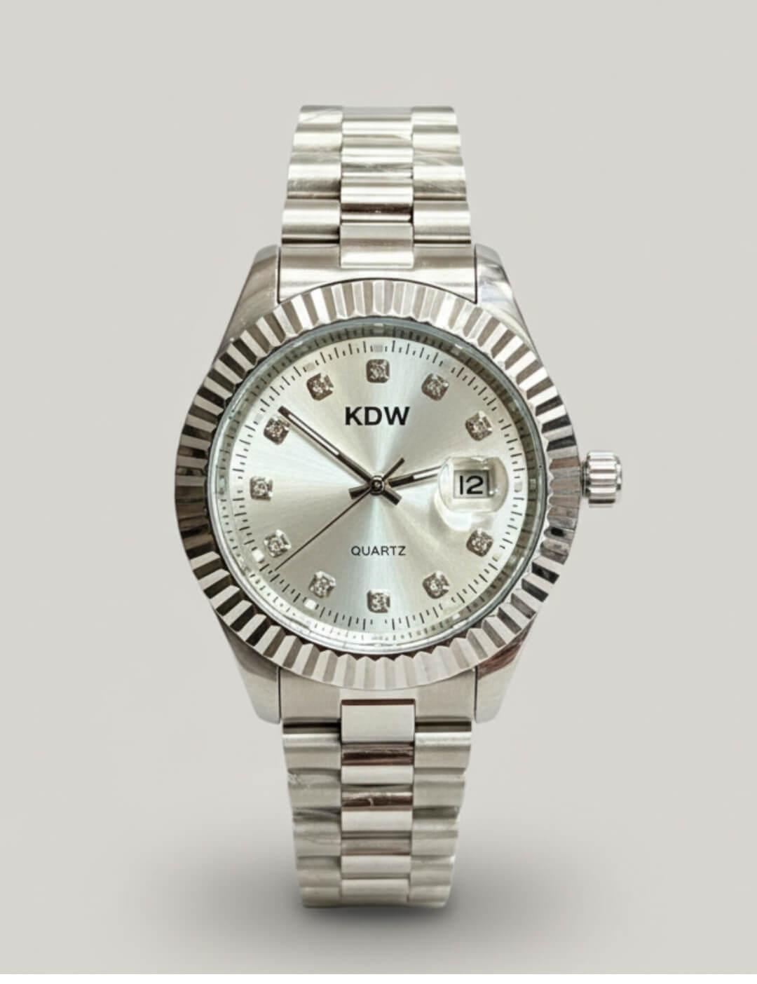 Silver Dial Stainless Steel Quartz Watch with a silver sunburst dial, fluted bezel, crystal-style hour markers, date window at three o’clock, and a polished metal link bracelet.
